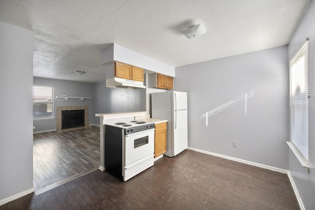 kitchen with dark wood finished floors, baseboards, under cabinet range hood, and white appliances