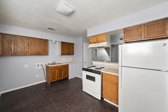 kitchen with brown cabinets, a sink, white appliances, under cabinet range hood, and visible vents