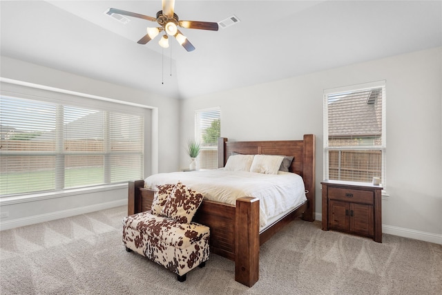 bedroom with light colored carpet, baseboards, visible vents, and lofted ceiling
