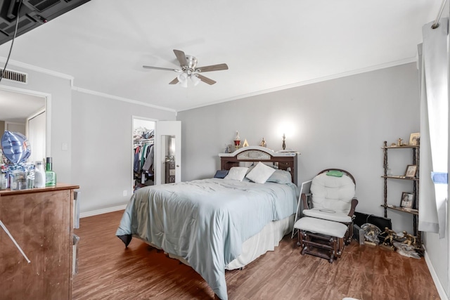bedroom with visible vents, ornamental molding, baseboards, and wood finished floors