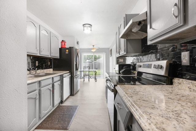 kitchen with under cabinet range hood, appliances with stainless steel finishes, decorative backsplash, and a sink