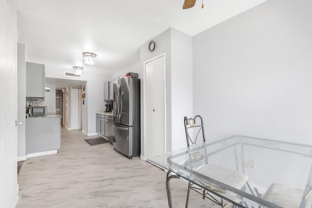 clothes washing area with visible vents, marble finish floor, baseboards, and ceiling fan