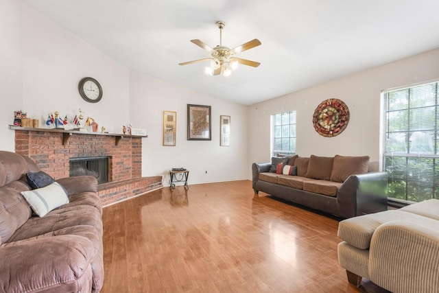 living area with ceiling fan, wood finished floors, lofted ceiling, and a fireplace