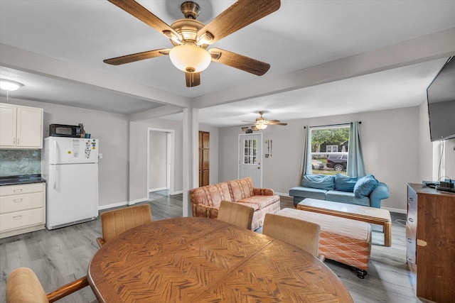 dining room with baseboards, a ceiling fan, and light wood-style floors