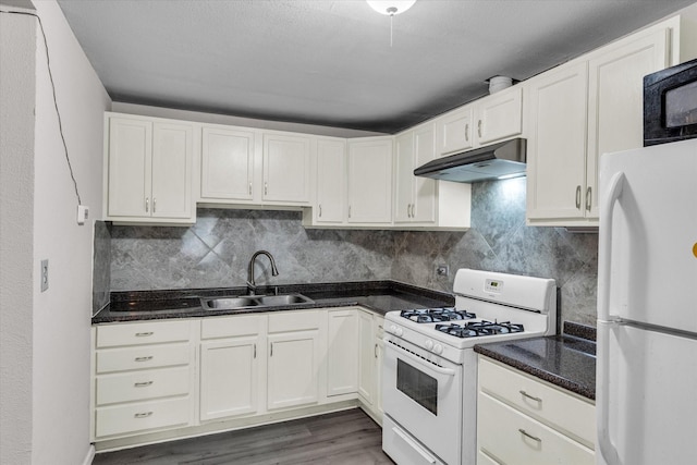 kitchen with backsplash, wood finished floors, a sink, under cabinet range hood, and white appliances