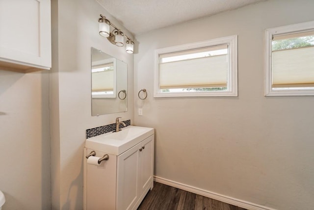 bathroom featuring vanity, baseboards, and wood finished floors