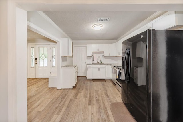 kitchen featuring white cabinets, a sink, range, light wood-type flooring, and black fridge with ice dispenser
