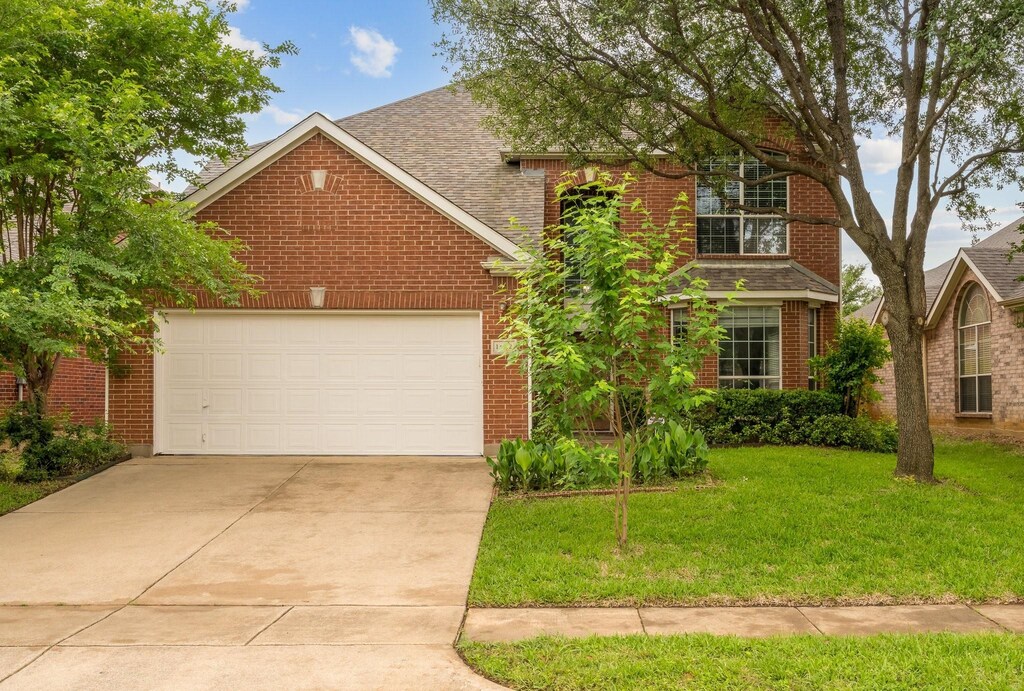 13232 Vista Glen Ln, Fort Worth, TX 76040 - traditional-style house featuring driveway, a front yard, brick siding, an attached garage, and a shingled roof