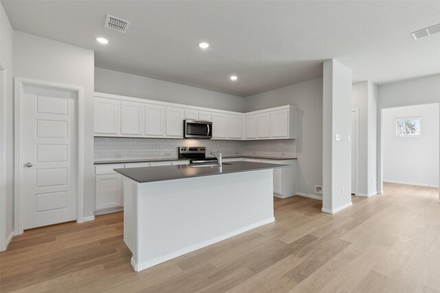 1946 Callington Way, Forney, TX 75126 - kitchen featuring stainless steel microwave, backsplash, light wood-style flooring, and white cabinetry