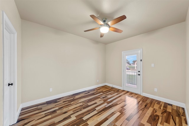 empty room with baseboards, ceiling fan, and wood finished floors