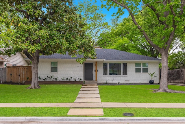 ranch-style home featuring brick siding, fence, roof with shingles, and a front lawn
