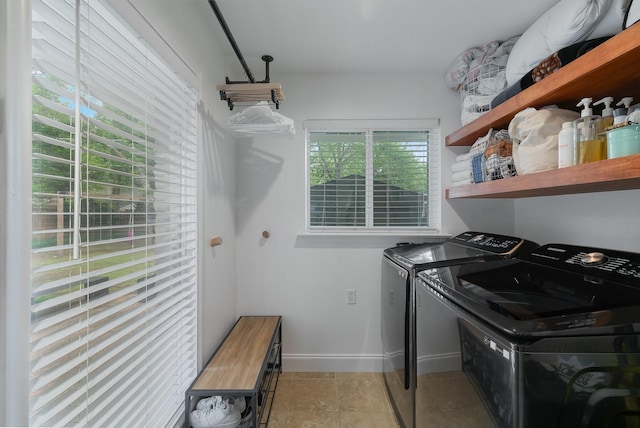 washroom with baseboards, laundry area, light tile patterned flooring, and washer and clothes dryer