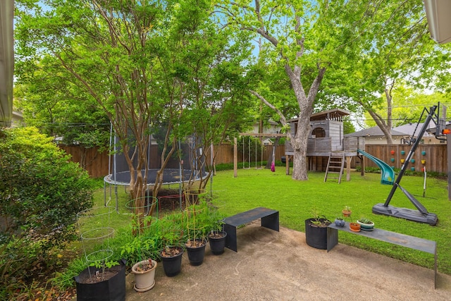 view of yard featuring a patio, a fenced backyard, a trampoline, and a playground