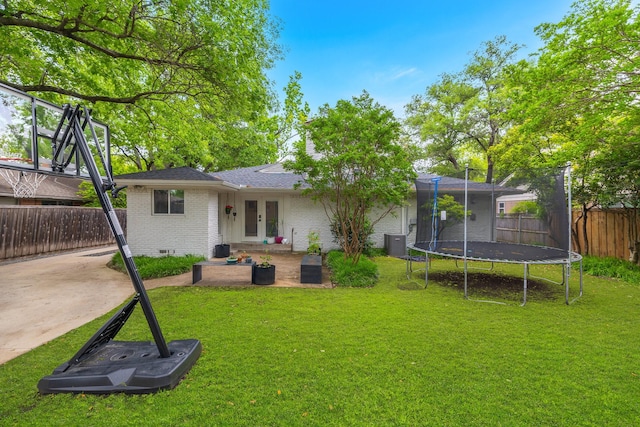 rear view of house with french doors, a trampoline, a lawn, central AC unit, and a patio