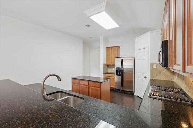 kitchen with a sink, dark wood finished floors, stainless steel appliances, tasteful backsplash, and visible vents