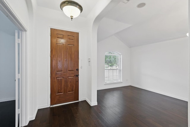 foyer featuring arched walkways, baseboards, vaulted ceiling, and dark wood finished floors