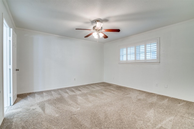 carpeted empty room with crown molding, ceiling fan, and baseboards