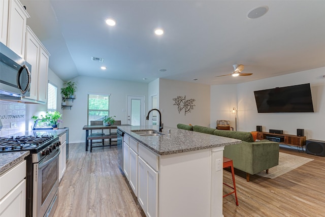 kitchen featuring visible vents, a sink, light wood-type flooring, and stainless steel appliances