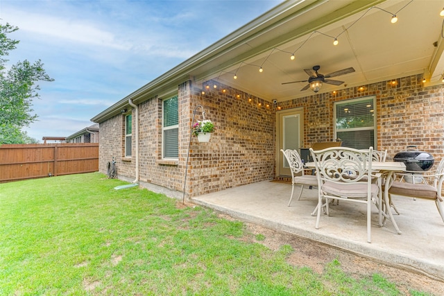 view of patio with fence, outdoor dining space, and ceiling fan