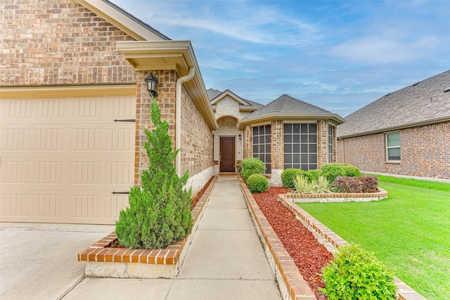 property entrance featuring a yard, brick siding, stone siding, and a garage