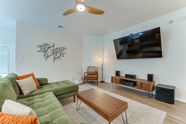living room featuring baseboards, ceiling fan, visible vents, and wood finished floors