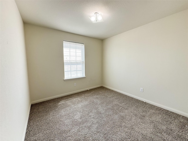 empty room featuring carpet floors and baseboards
