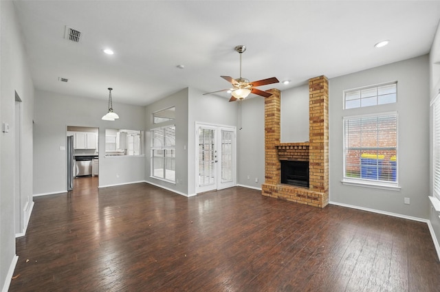 6317 N Park Dr, Watauga, TX 76148 - unfurnished living room with a ceiling fan, dark wood finished floors, a brick fireplace, and visible vents