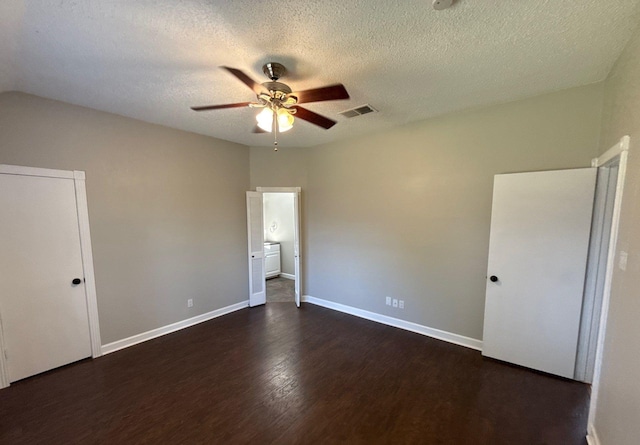 unfurnished bedroom with a textured ceiling, dark wood finished floors, a ceiling fan, baseboards, and visible vents