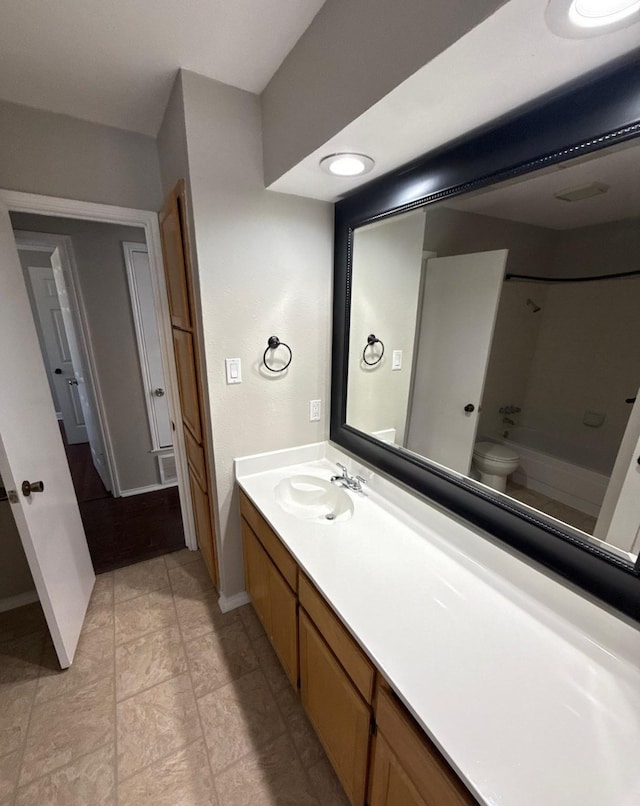 full bath with vanity, baseboards, and toilet