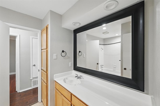 6317 N Park Dr, Watauga, TX 76148 - bathroom featuring visible vents, wood finished floors, vanity, baseboards, and washtub / shower combination