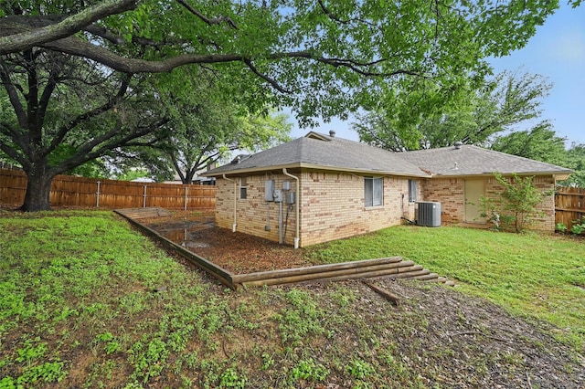 6317 N Park Dr, Watauga, TX 76148 - back of property with roof with shingles, a lawn, brick siding, cooling unit, and a fenced backyard