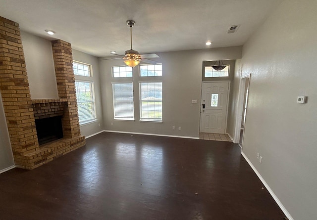 unfurnished living room with a ceiling fan, baseboards, wood finished floors, and a fireplace