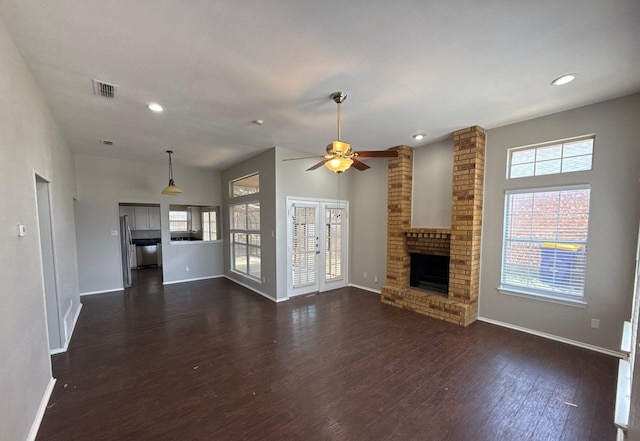 unfurnished living room with baseboards, a fireplace, dark wood finished floors, and visible vents