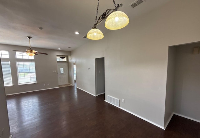 interior space featuring a ceiling fan, baseboards, visible vents, and dark wood-style floors