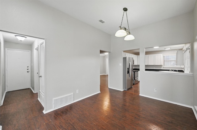 6317 N Park Dr, Watauga, TX 76148 - unfurnished living room featuring visible vents, dark wood-style flooring, and baseboards