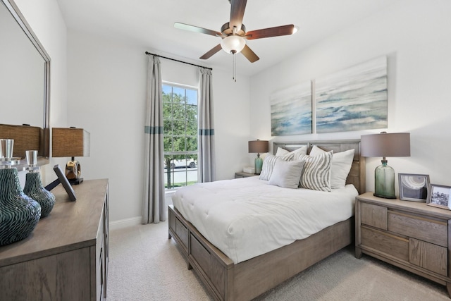 bedroom with baseboards, ceiling fan, and light carpet