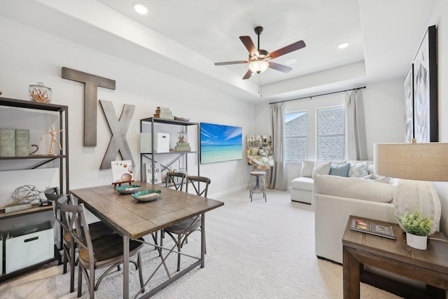 interior space featuring light carpet, baseboards, ceiling fan, recessed lighting, and a raised ceiling