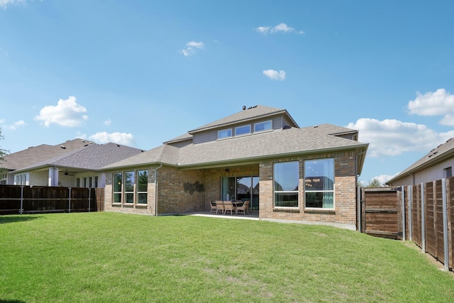 rear view of house with brick siding, a shingled roof, and a fenced backyard