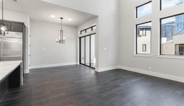 interior space with dark wood-style flooring, baseboards, and a chandelier