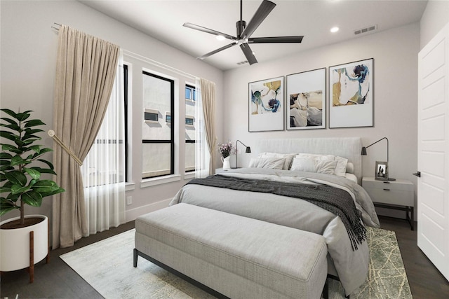 bedroom featuring a ceiling fan, visible vents, dark wood finished floors, baseboards, and recessed lighting