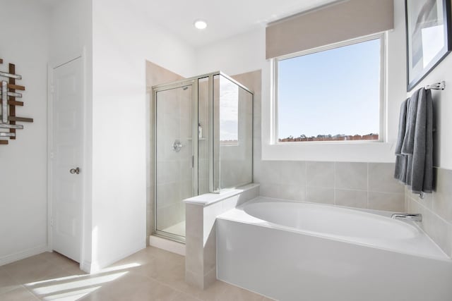 bathroom featuring tile patterned floors, a bath, and a stall shower