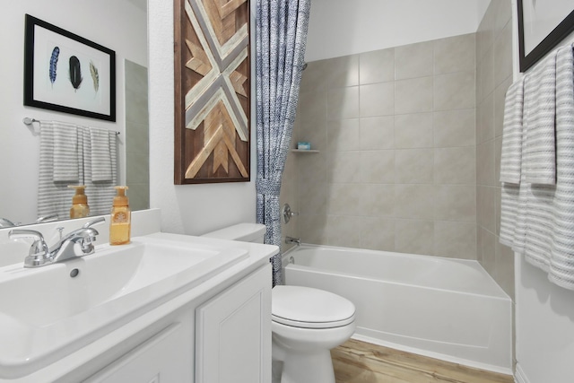full bath featuring vanity, wood finished floors, toilet, and shower / washtub combination
