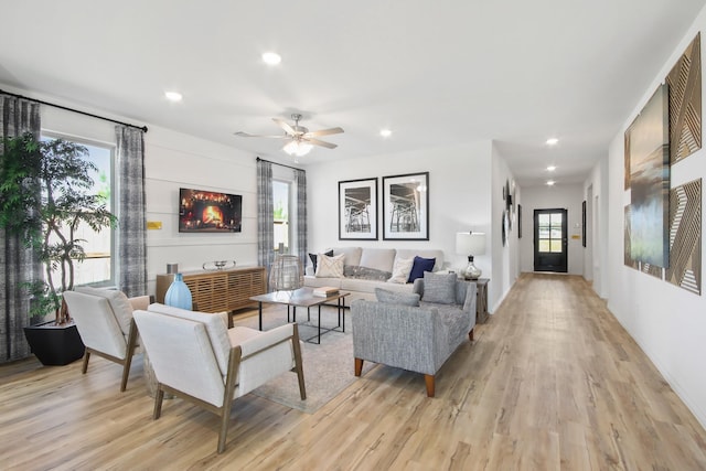 living room featuring recessed lighting, a ceiling fan, and light wood-type flooring