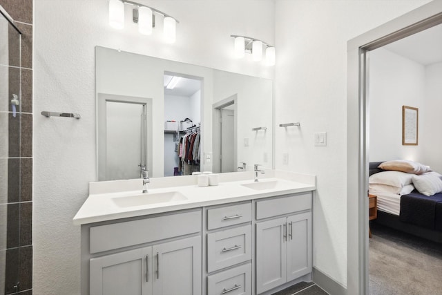 8613 Keeneland Dr, Fort Worth, TX 76120 - bathroom with double vanity, a walk in closet, a sink, and ensuite bathroom