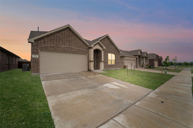 859 Sitwell Dr, Fate, TX 75087 - view of front of house with brick siding, an attached garage, a lawn, and driveway
