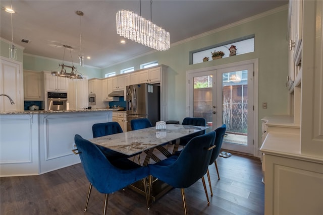 dining space featuring french doors, ornamental molding, and dark wood finished floors