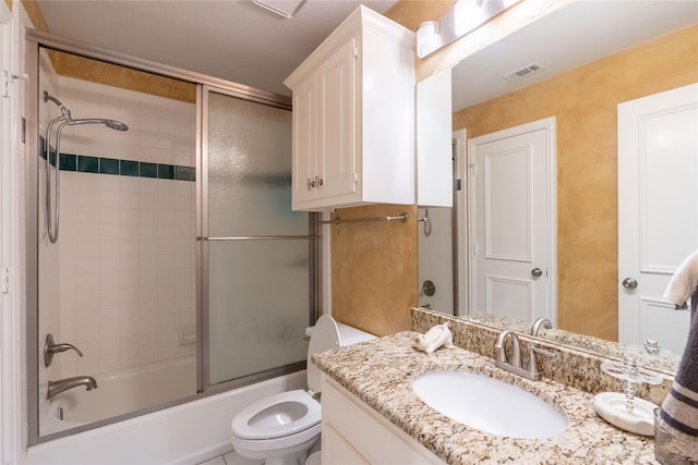 bathroom with bath / shower combo with glass door, vanity, toilet, and visible vents