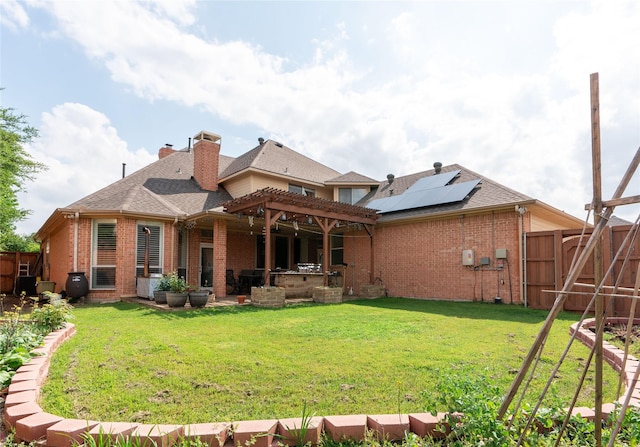 rear view of house with a pergola, brick siding, a fenced backyard, a chimney, and a yard