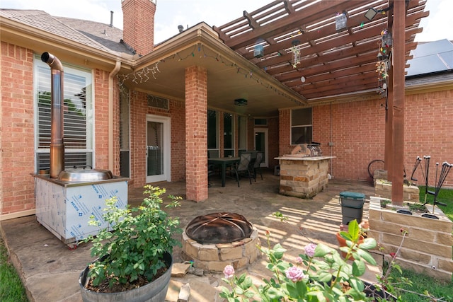 view of patio with outdoor dining area, a fire pit, and a pergola