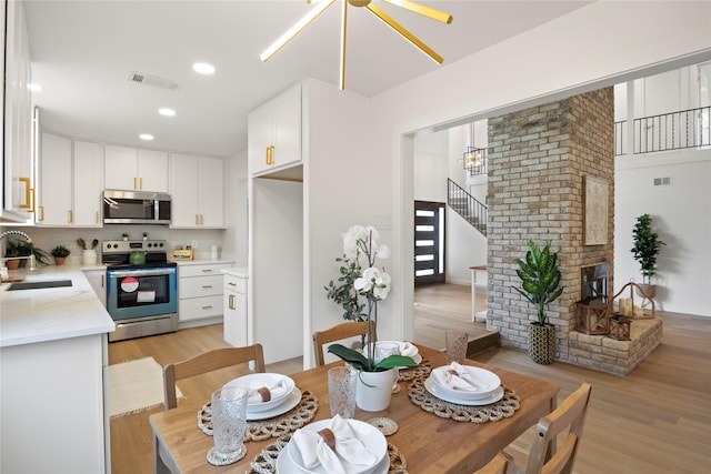 dining area featuring recessed lighting, visible vents, and light wood-style flooring